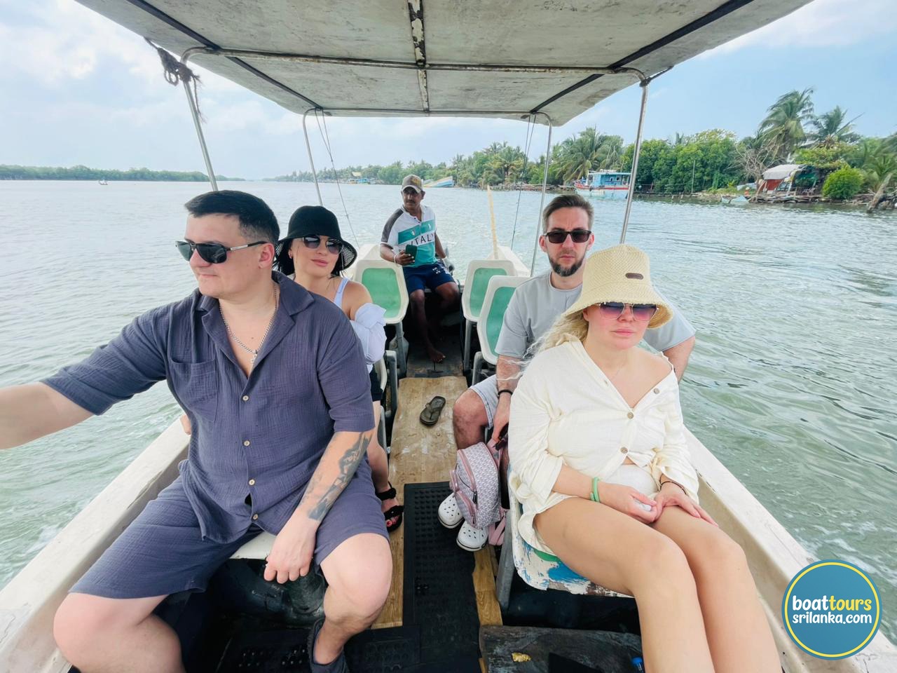 Tourists enjoying a guided boat tour on Negombo Lagoon Sri Lanka with local boat captain